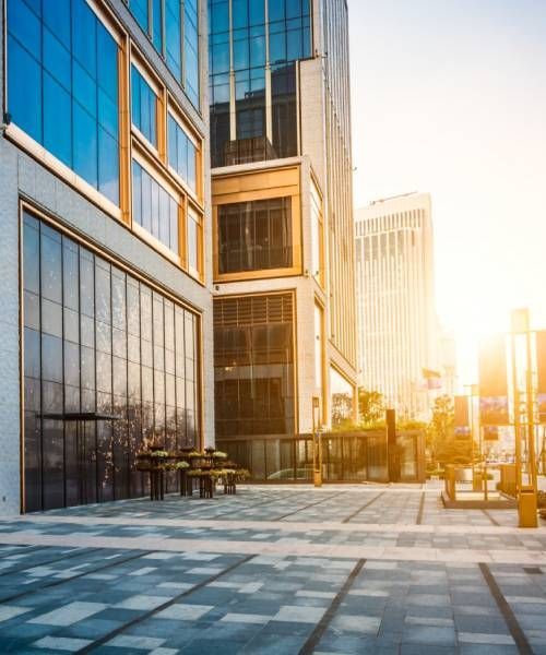 A large building with a lot of windows is in the middle of a city.