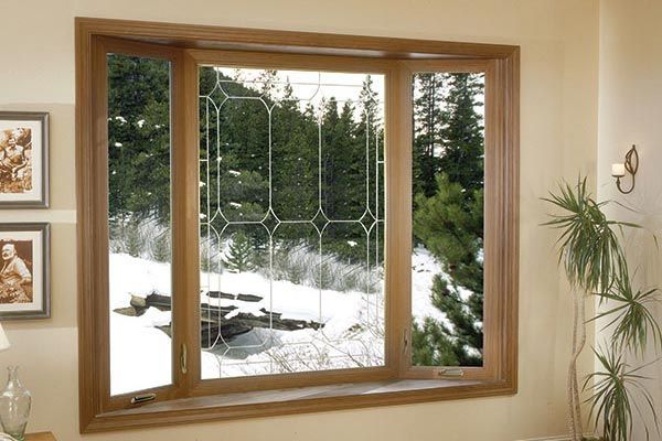 A living room with a large window looking out to a snowy forest