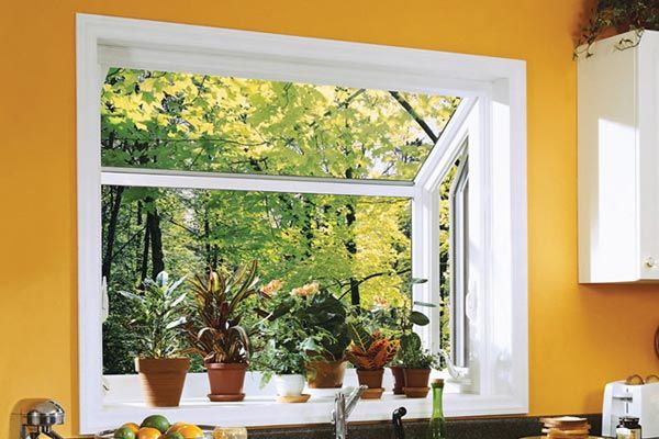 A kitchen with potted plants on a window sill