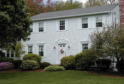 A large white house with a wreath on the door