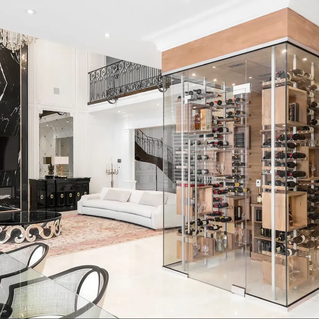 Modern living room with white sofa, glass wine display cabinet, and staircase balcony