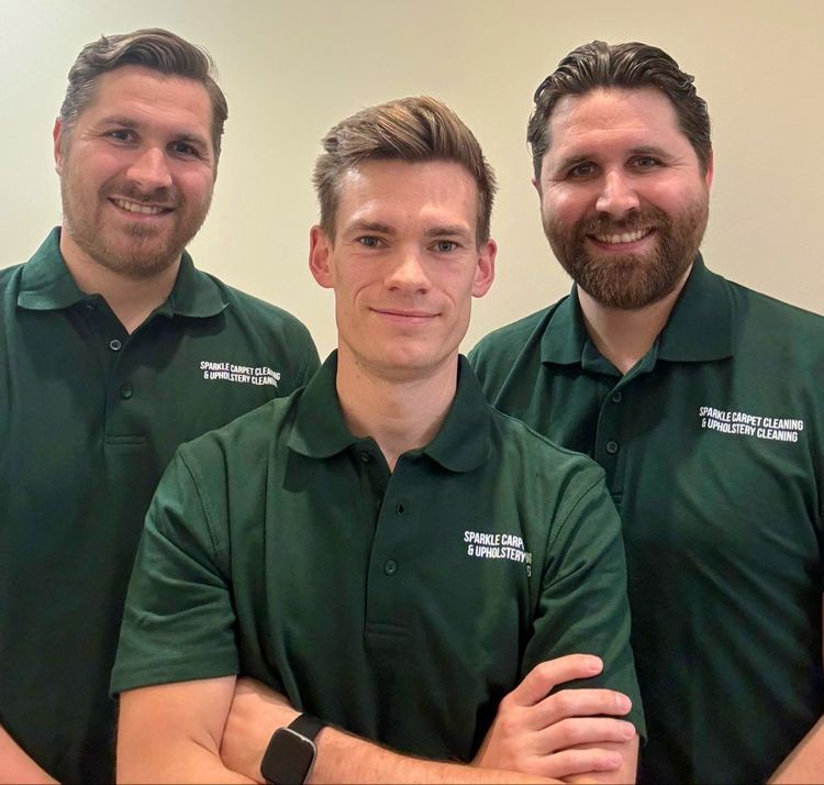 Three men are posing for a picture and one of them is wearing a shirt that says ' fullerton ' on it