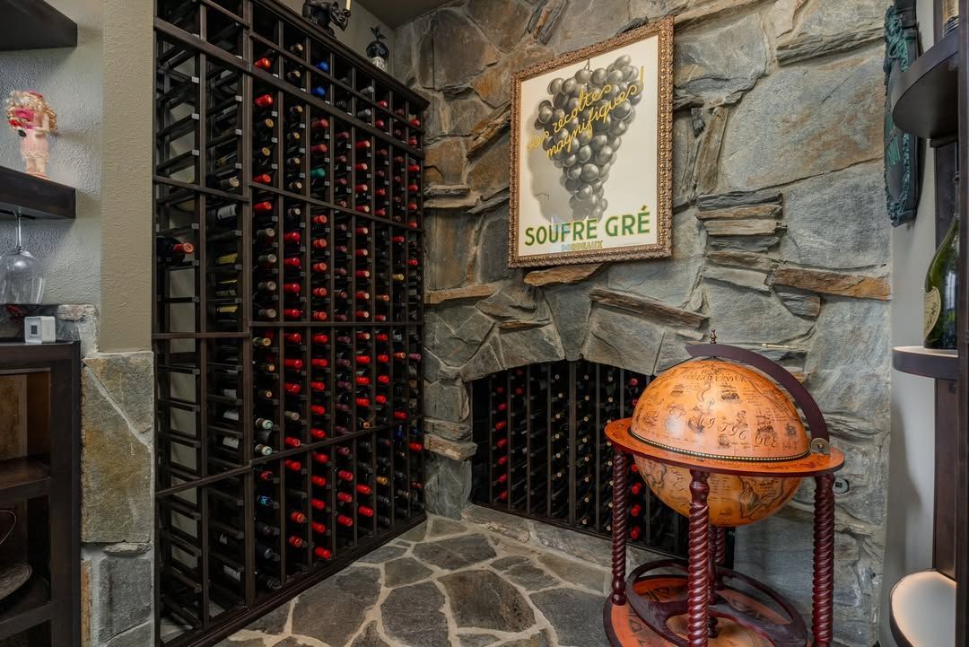 Stone wine cellar with a wine rack, arched niche, and copper globe on a stand