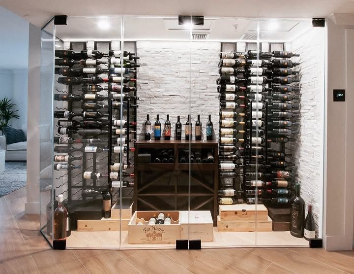 Wine storage display with floor-to-ceiling racks and a central shelf of bottles in a modern room