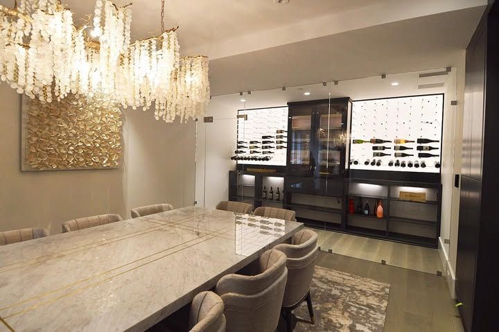 Luxurious dining room with marble table, crystal chandelier, and glass wine cabinet