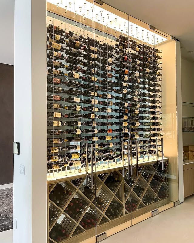 Floor-to-ceiling glass wine display with rows of bottles in a modern interior