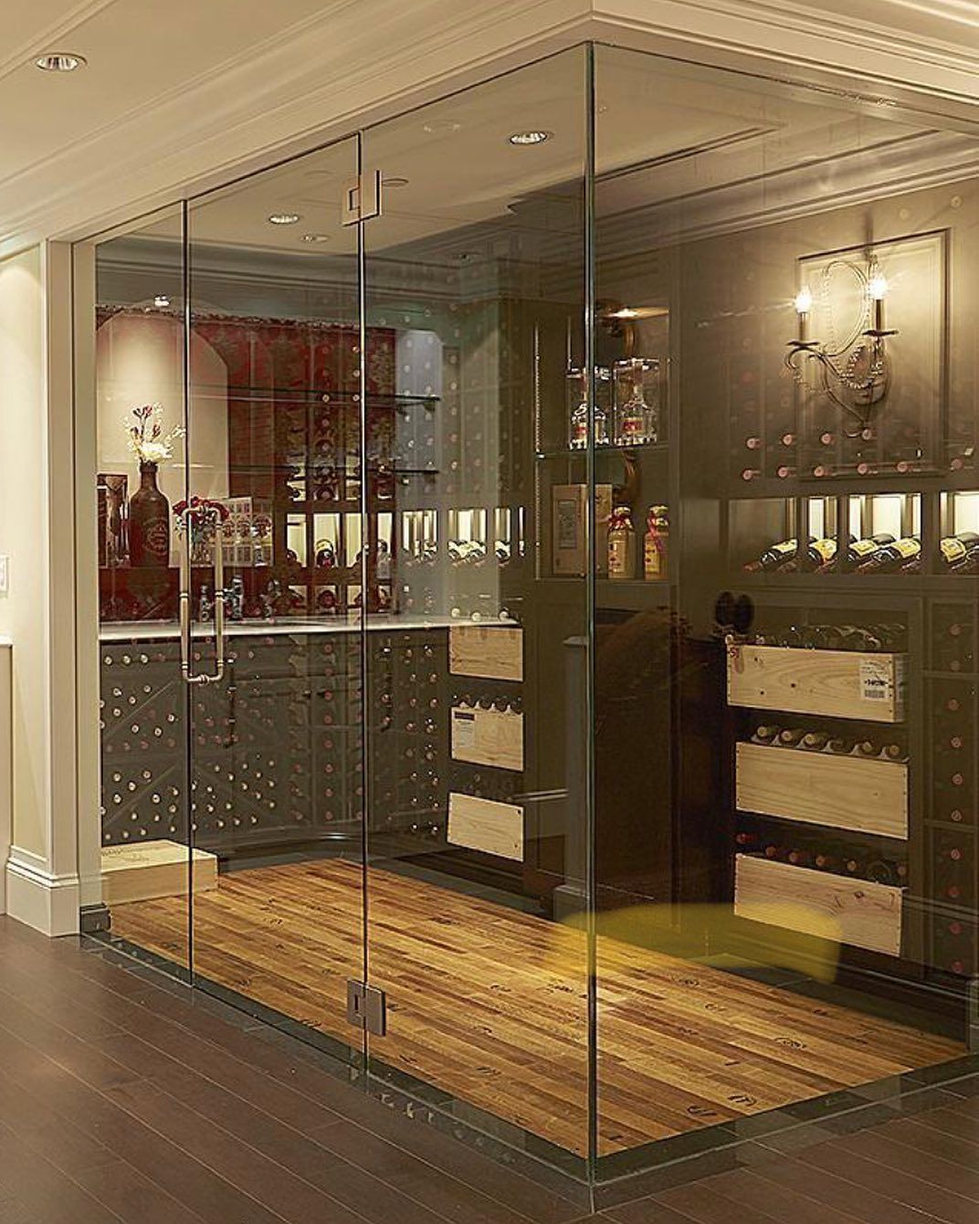 Glass-enclosed wine room with wooden floor and built-in wine racks in a warm, elegant interior