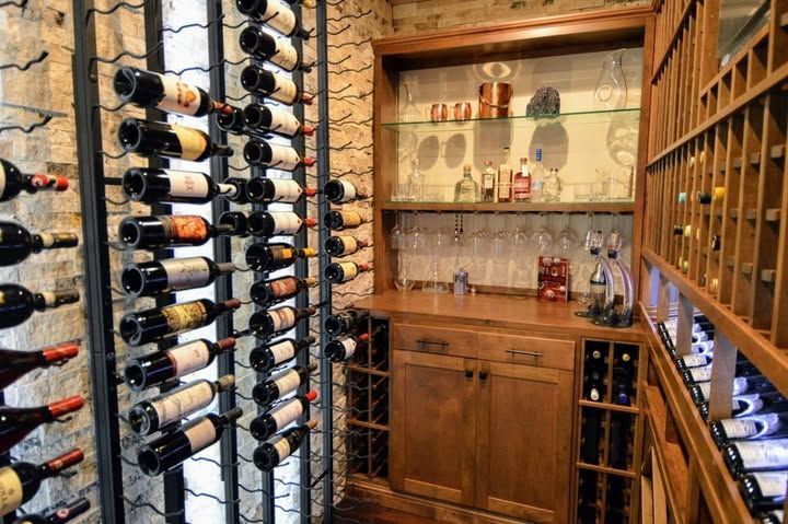Wine cellar with wooden racks and shelves filled with bottles and glassware