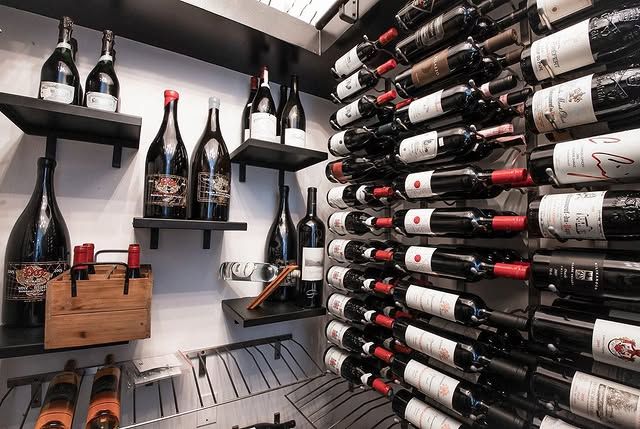 Wine cellar with rows of bottles on wall racks and shelves