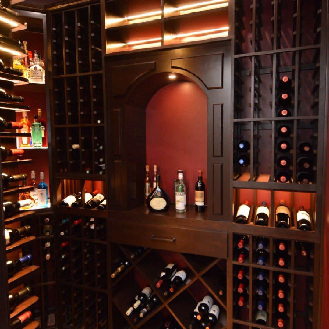 Warm-lit wine cellar with built-in racks and bottles displayed in dark wood shelving