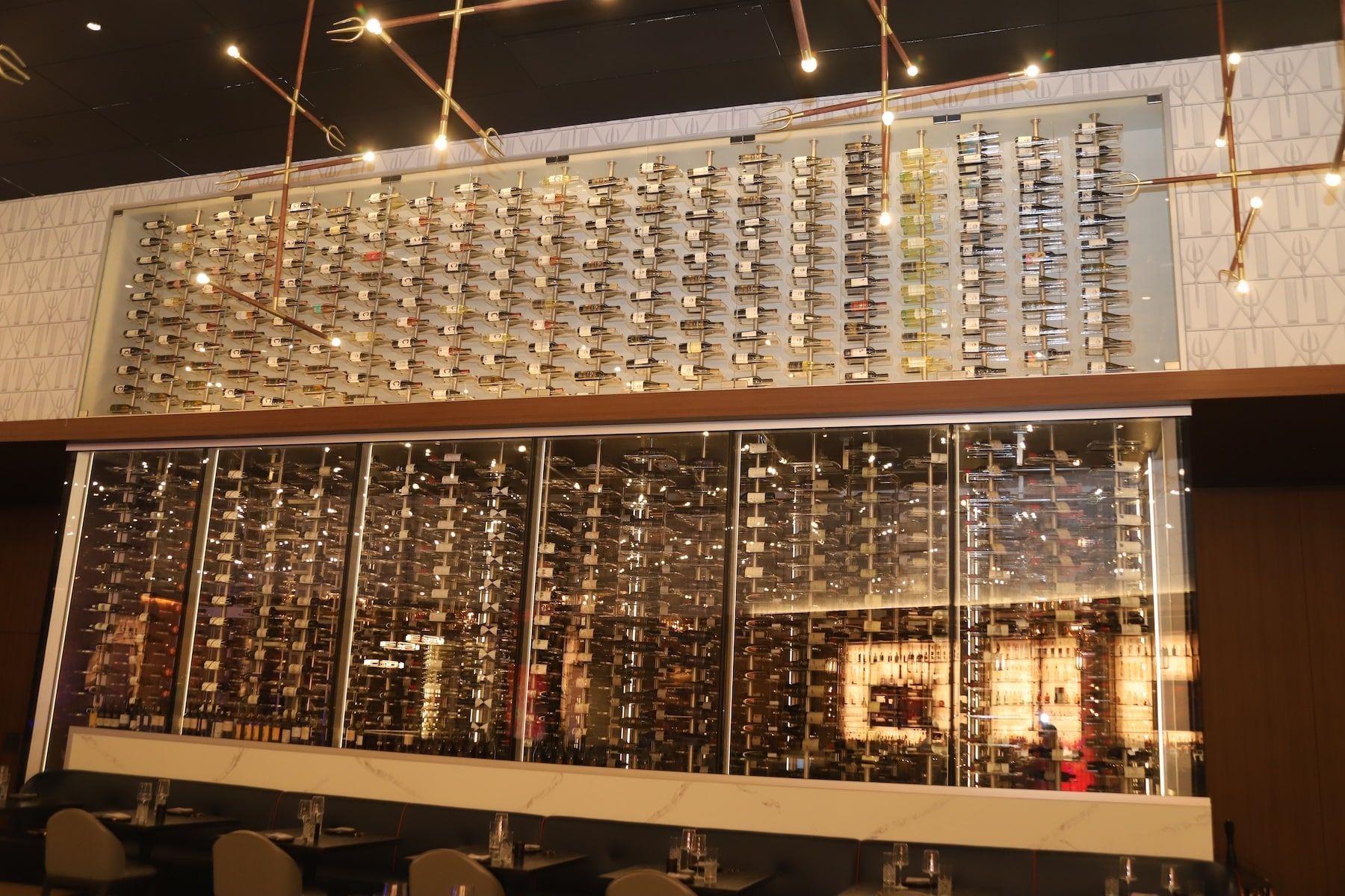 Modern interior with a large mirrored glass wall and warm hanging lights