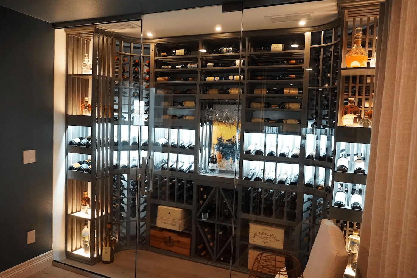 Glass-front wine cellar with rows of bottles and warm accent lighting