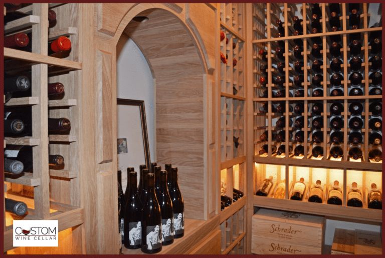 Wooden wine cellar with arched doorway, bottle racks, and wine bottles on display