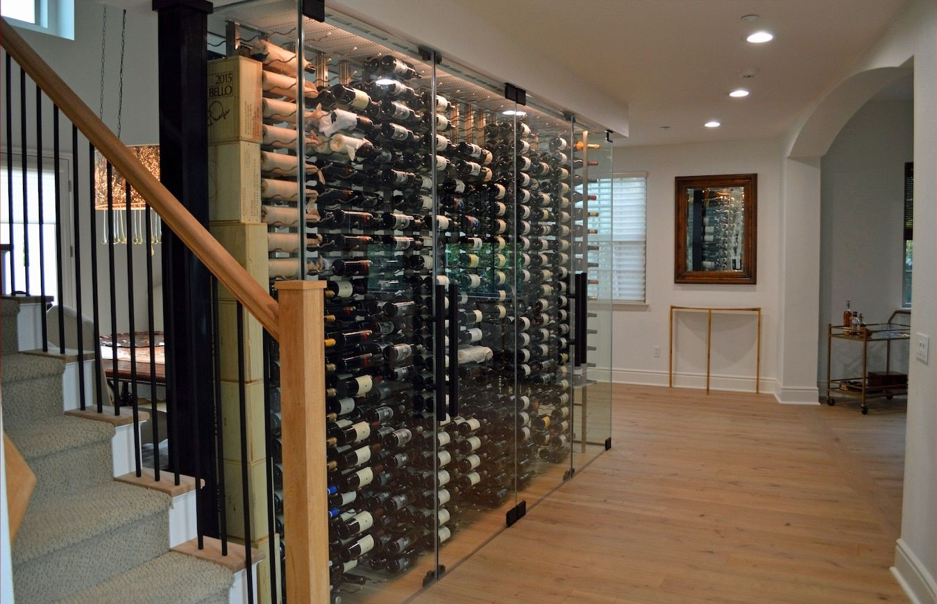 Modern home hallway with a floor-to-ceiling wine rack and staircase beside it