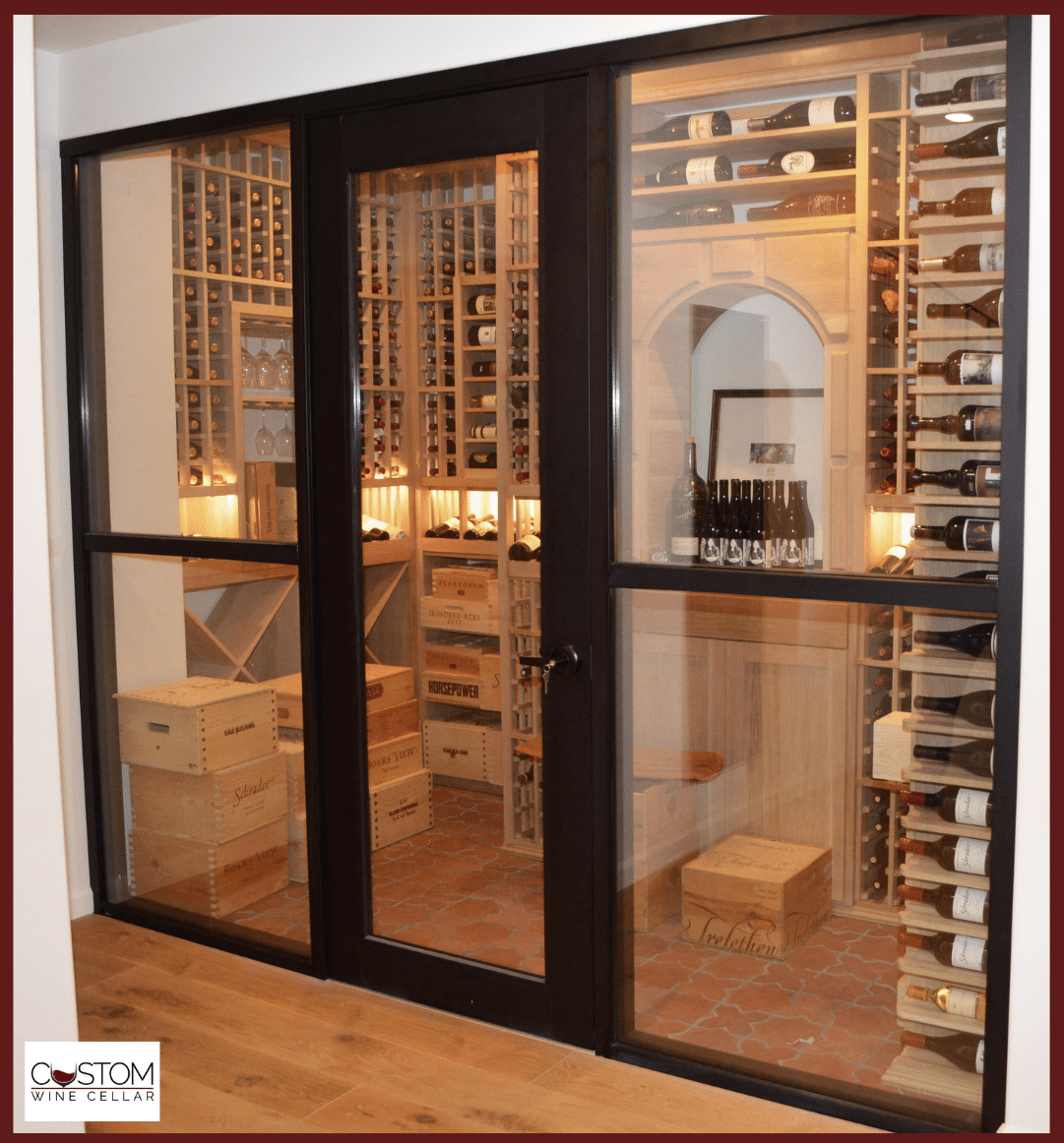 Glass-front wine cellar with wooden racks and bottles in a warm-lit room