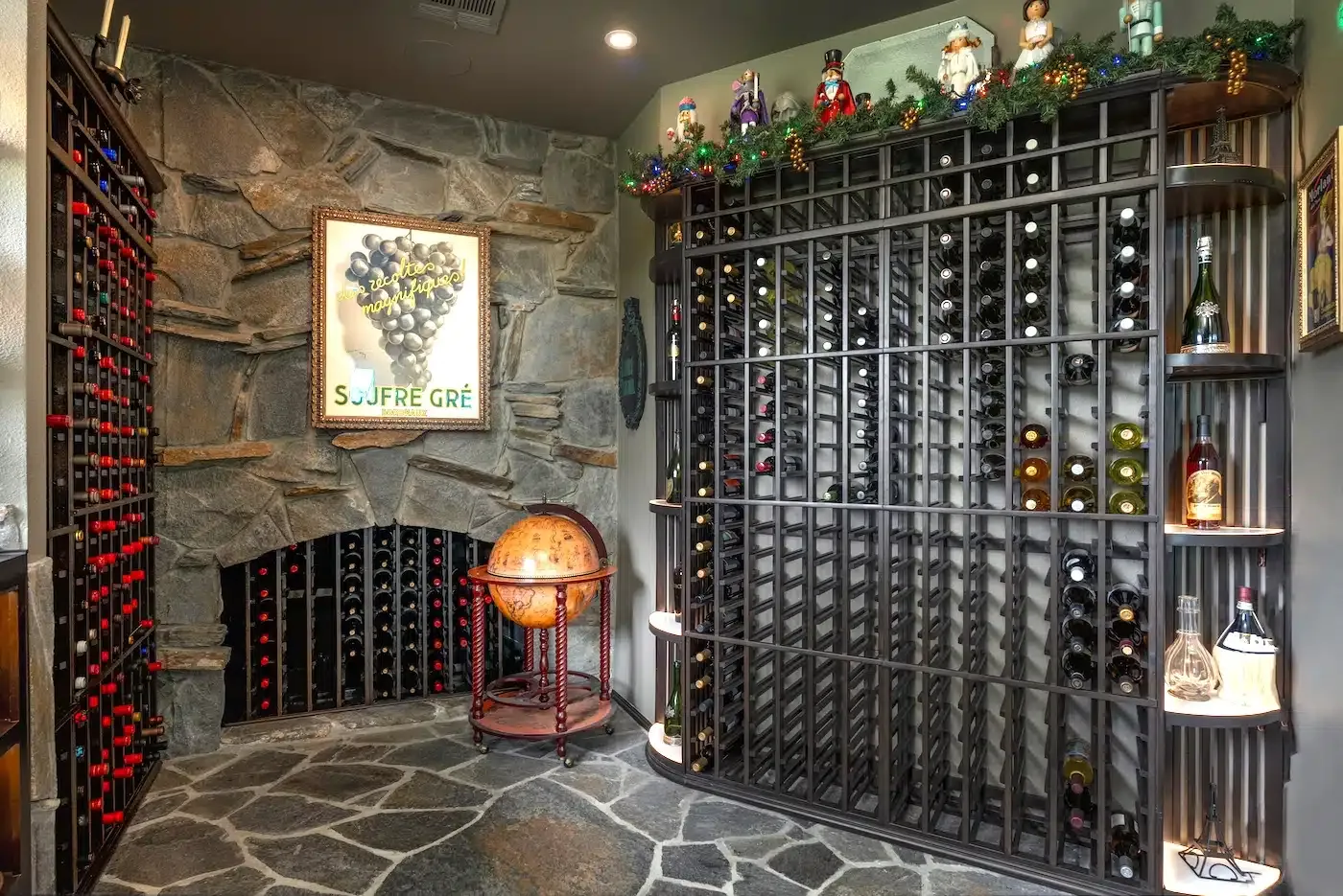 Wine cellar with floor-to-ceiling racks, stone walls, and a decorative globe lamp.