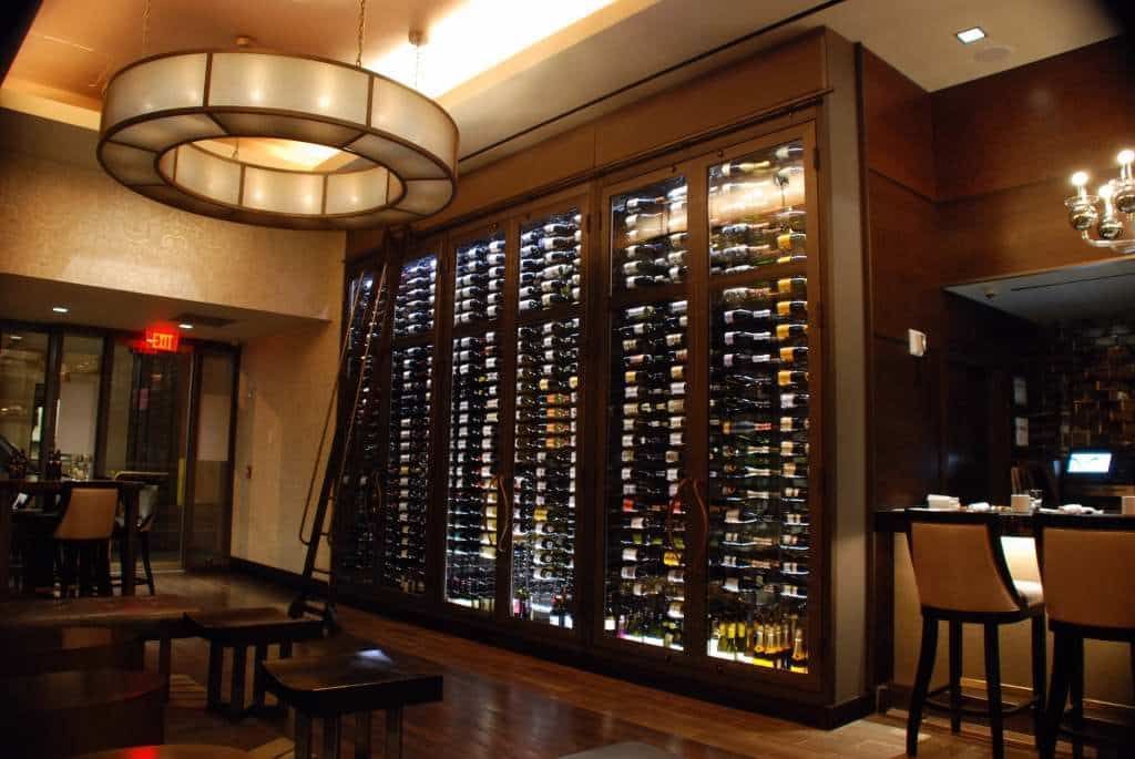 Elegant restaurant interior with a large wine display and warm ambient lighting