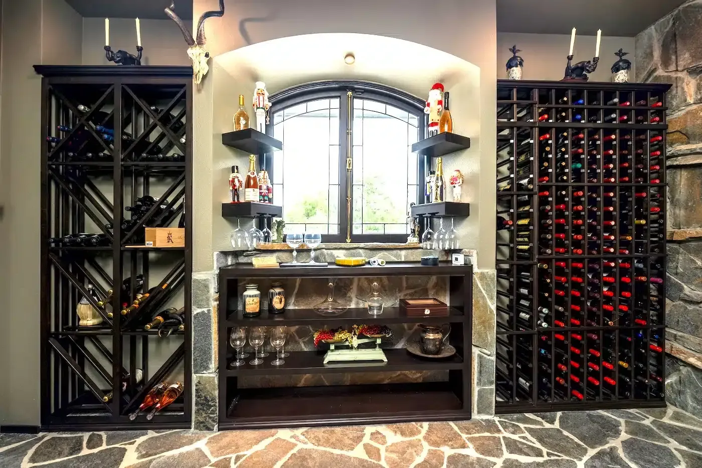 Elegant home wine cellar with glass-front shelves, arched window, and tiled floor