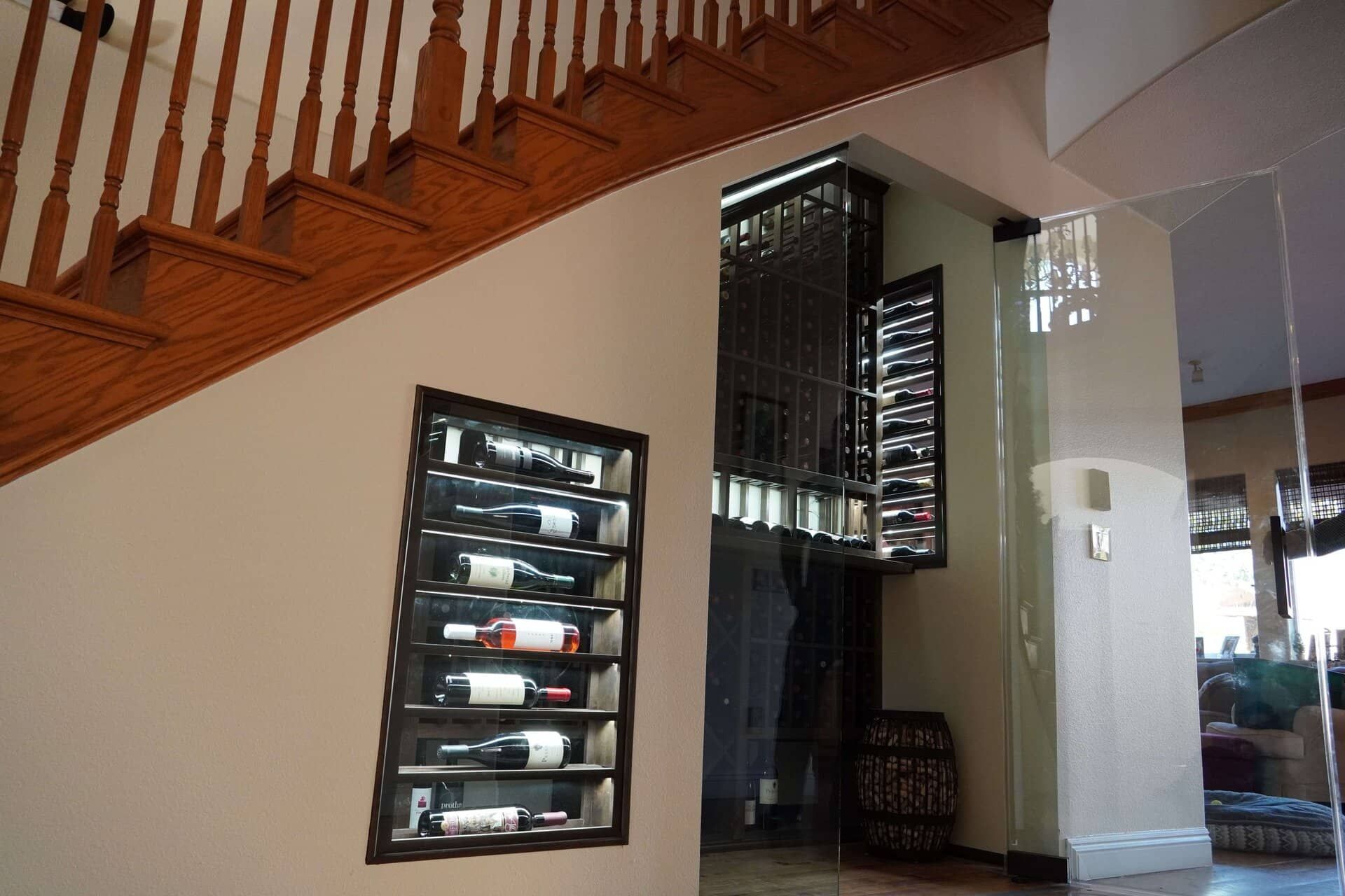 Interior with wooden staircase, wine rack, and large mirror in a modern home foyer
