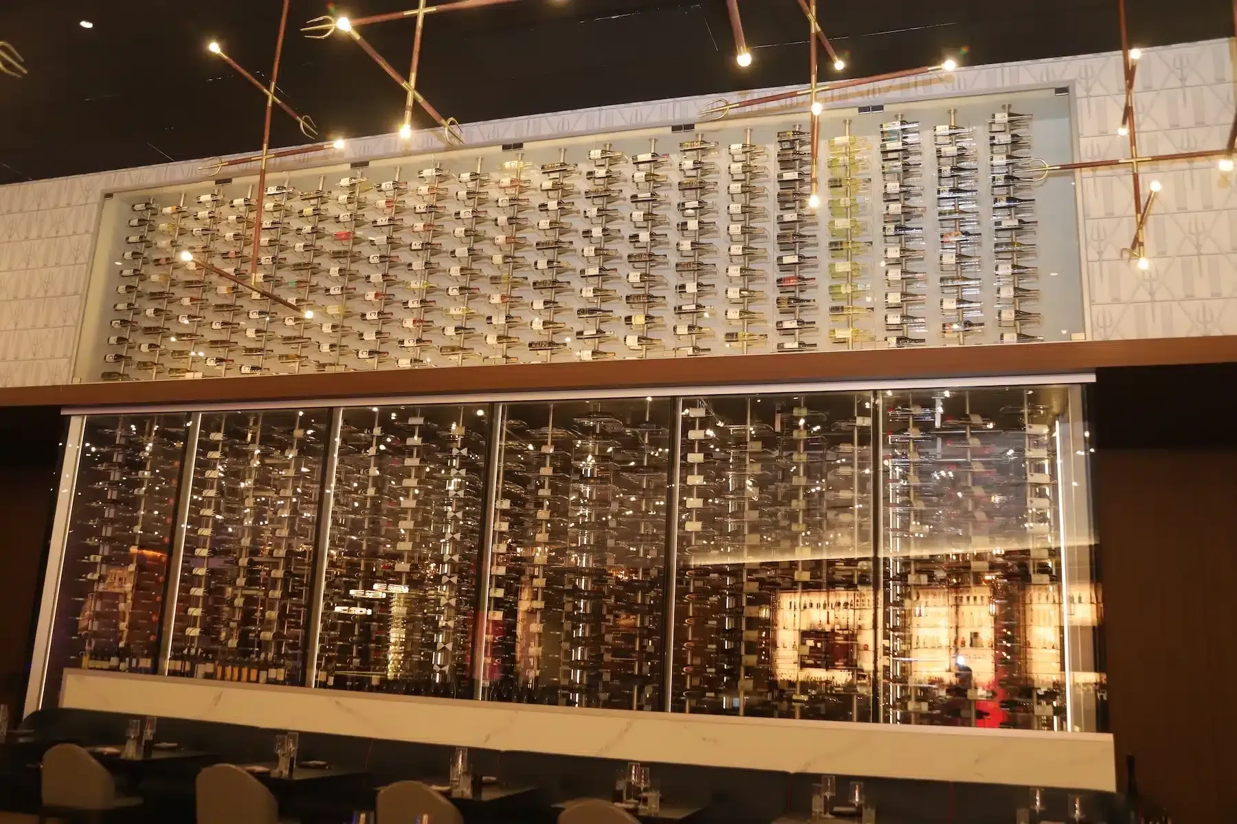 Modern interior with a tall wall of hanging glass or crystal panels and warm ceiling lights