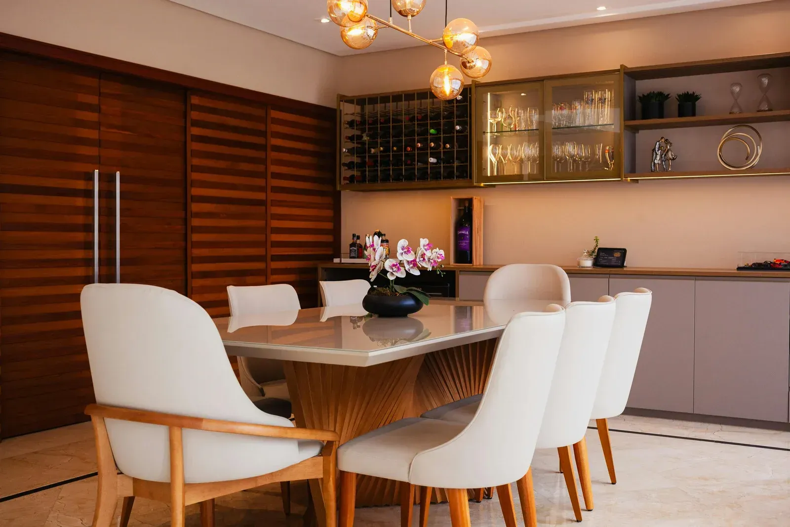 Dining room with a table, chairs, and a bar area.