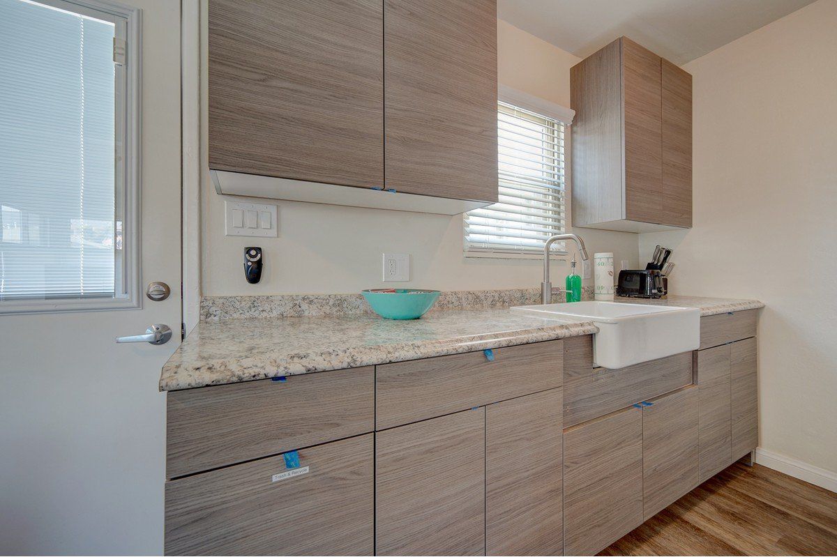 a kitchen with a sink , cabinets , and a window .