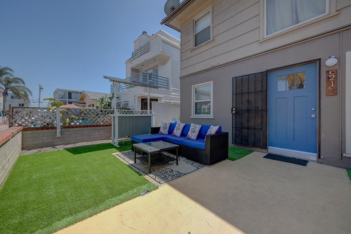 A house with a blue door and a couch in front of it.