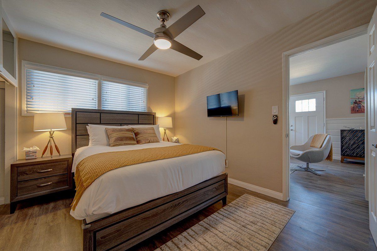 A bedroom with a king size bed and a ceiling fan.