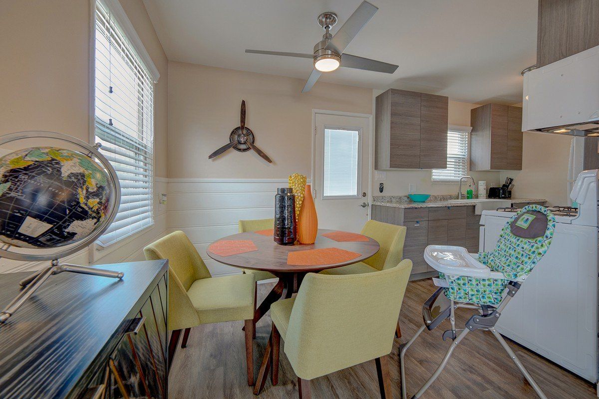 A dining room with a table and chairs and a high chair.
