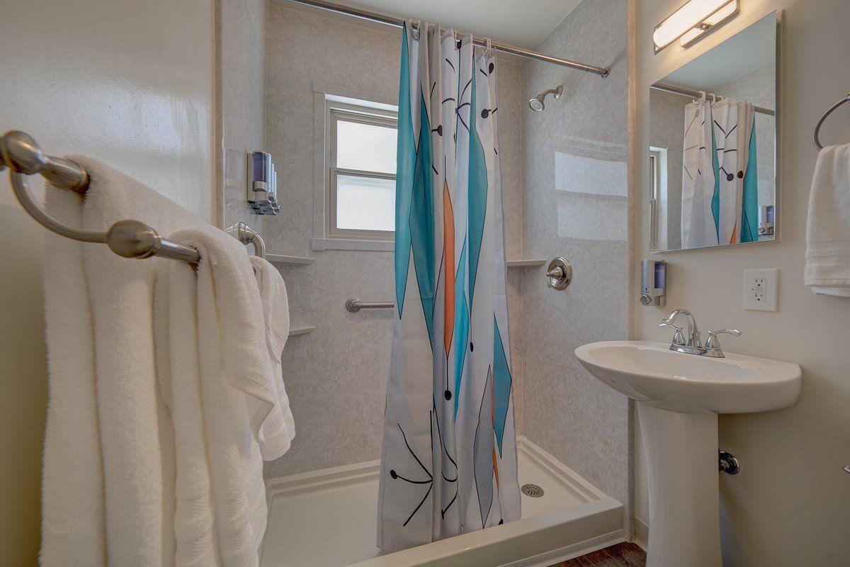 a bathroom with a sink , shower , and mirror .