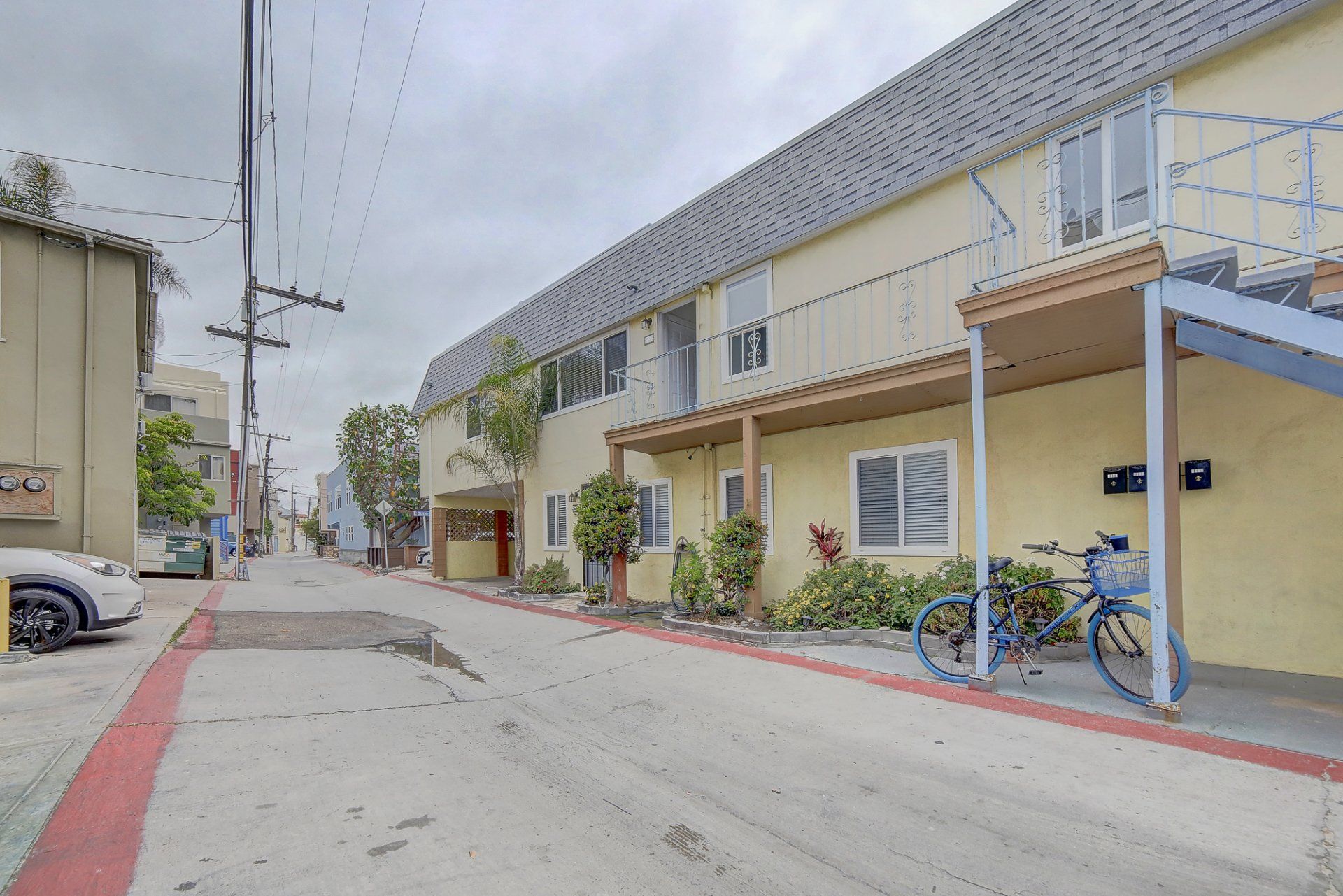 a bicycle is parked in front of a yellow apartment building .