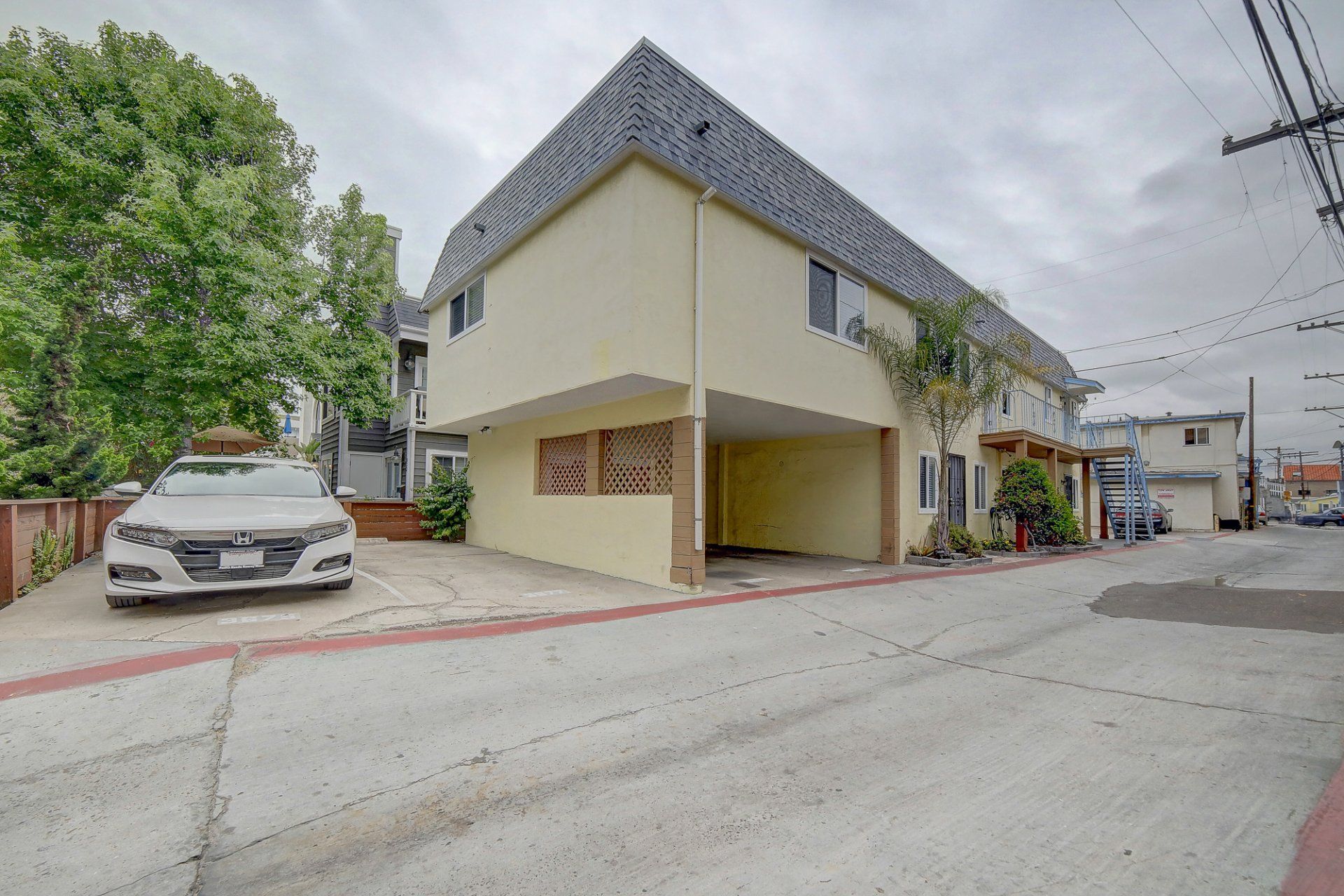 a white car is parked in front of a yellow building