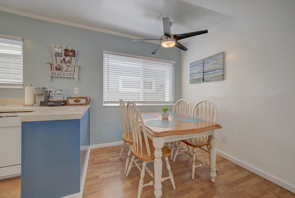 a dining room with a table and chairs and a ceiling fan .