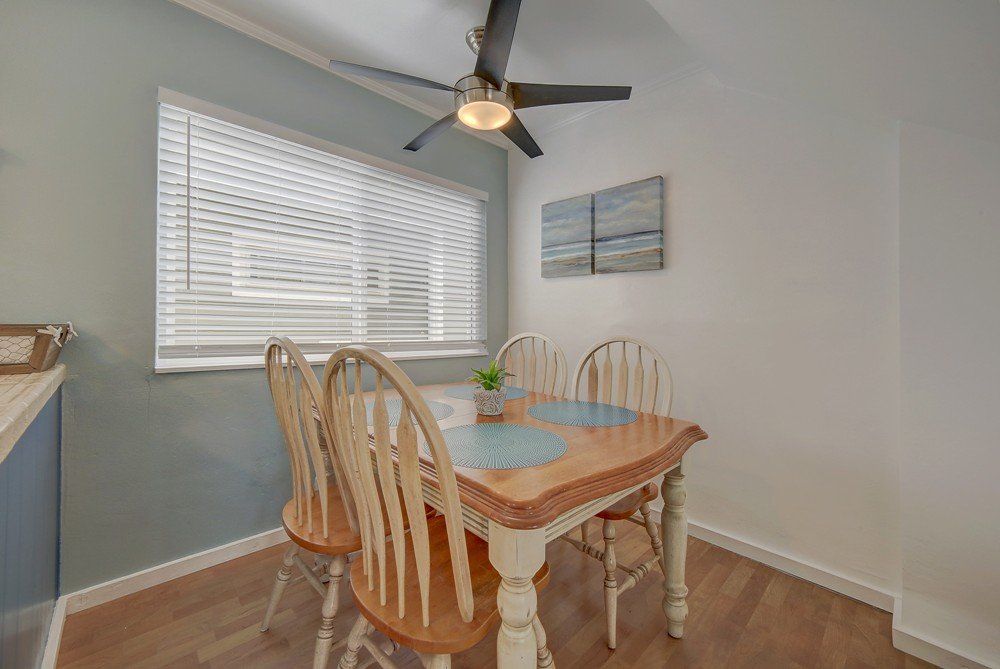 a dining room with a table and chairs and a ceiling fan .