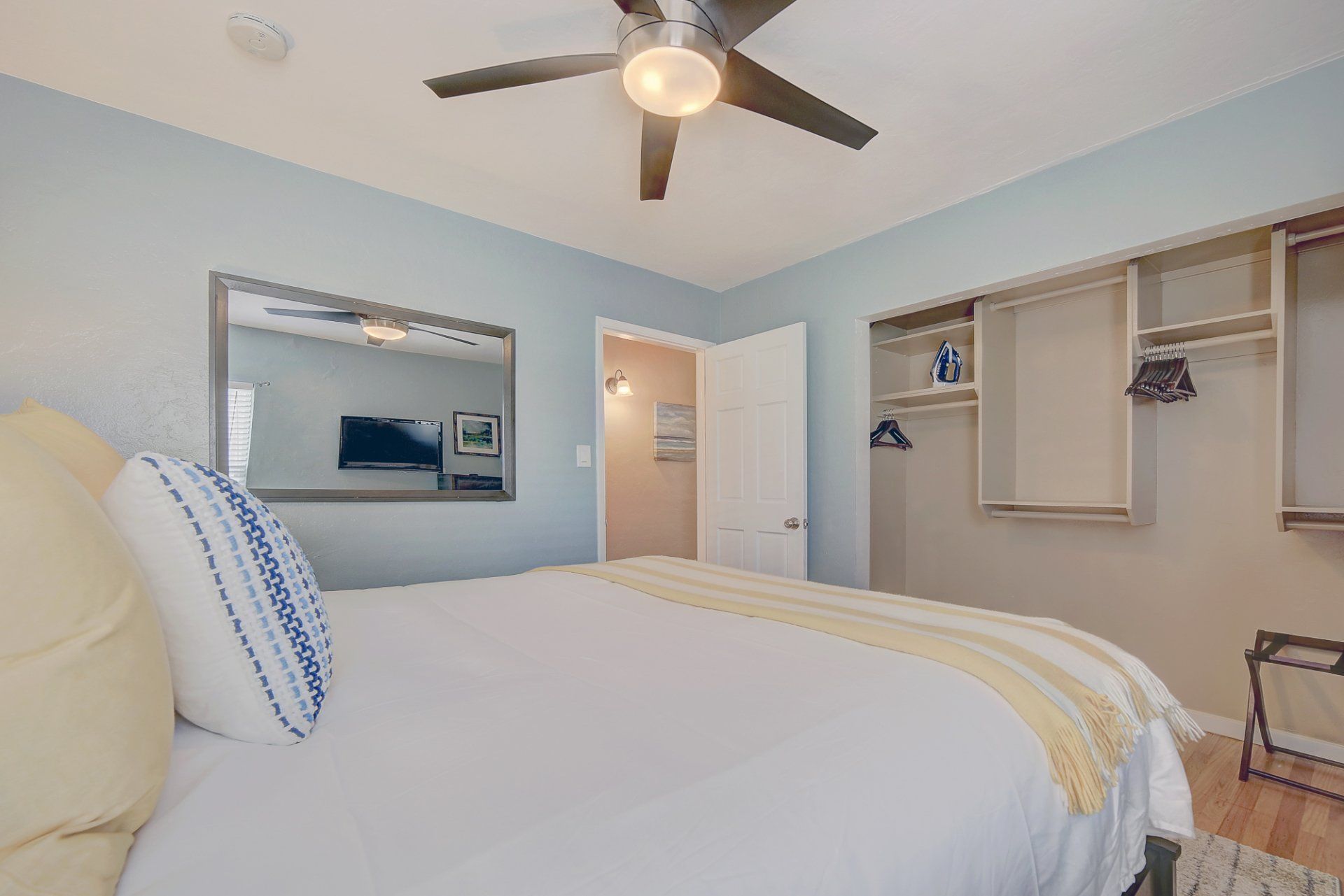 A bedroom with a king size bed and a ceiling fan.