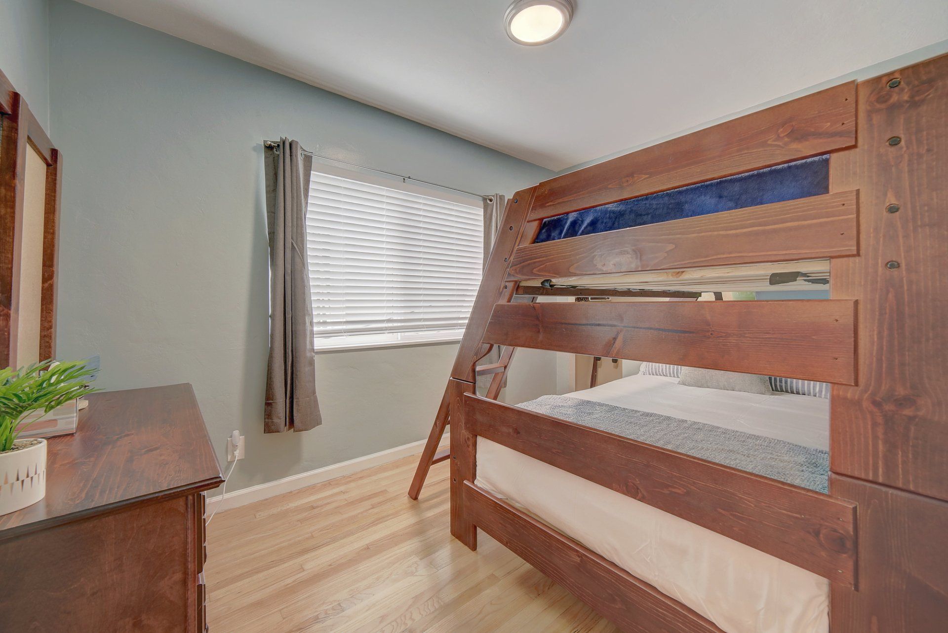 a bedroom with a bunk bed and a dresser .