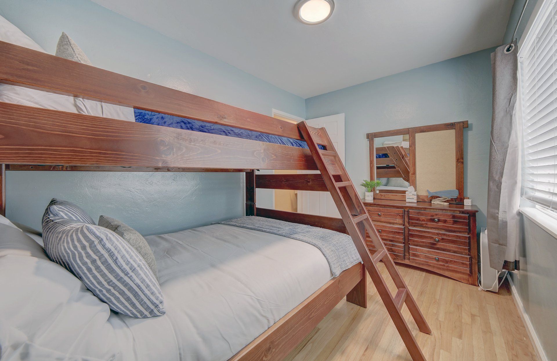 a bedroom with a bunk bed and a dresser .