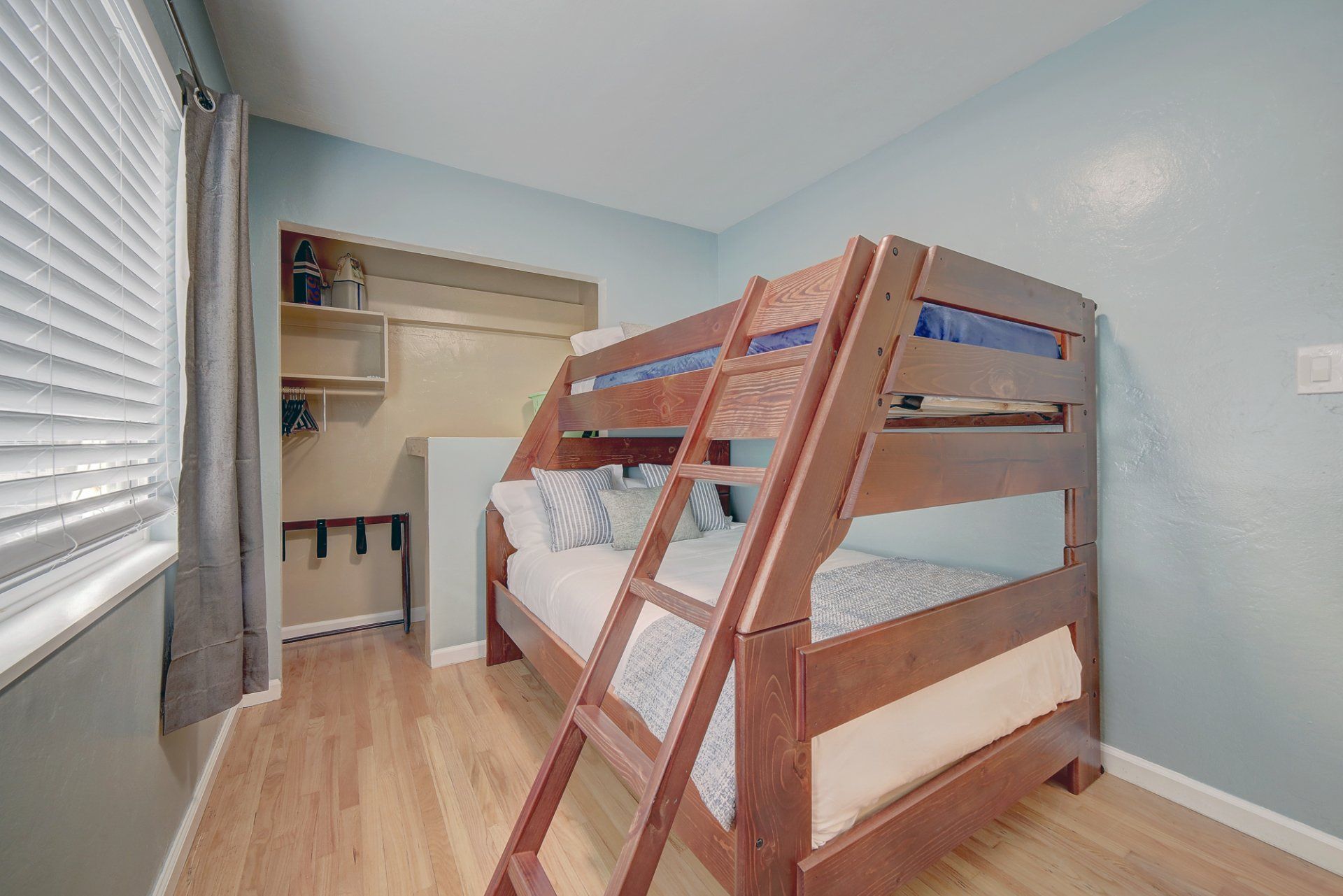 a bunk bed with a ladder in a bedroom next to a window .