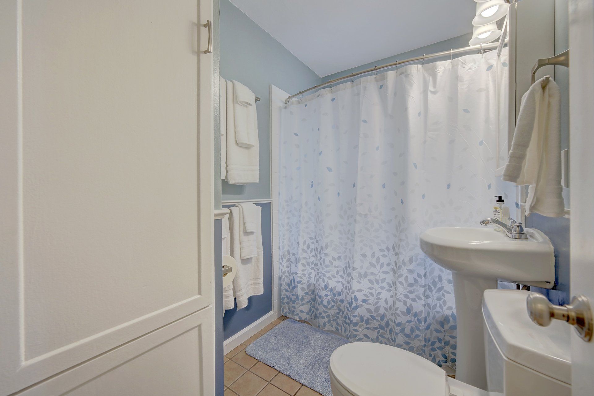 A bathroom with a toilet , sink and shower curtain.