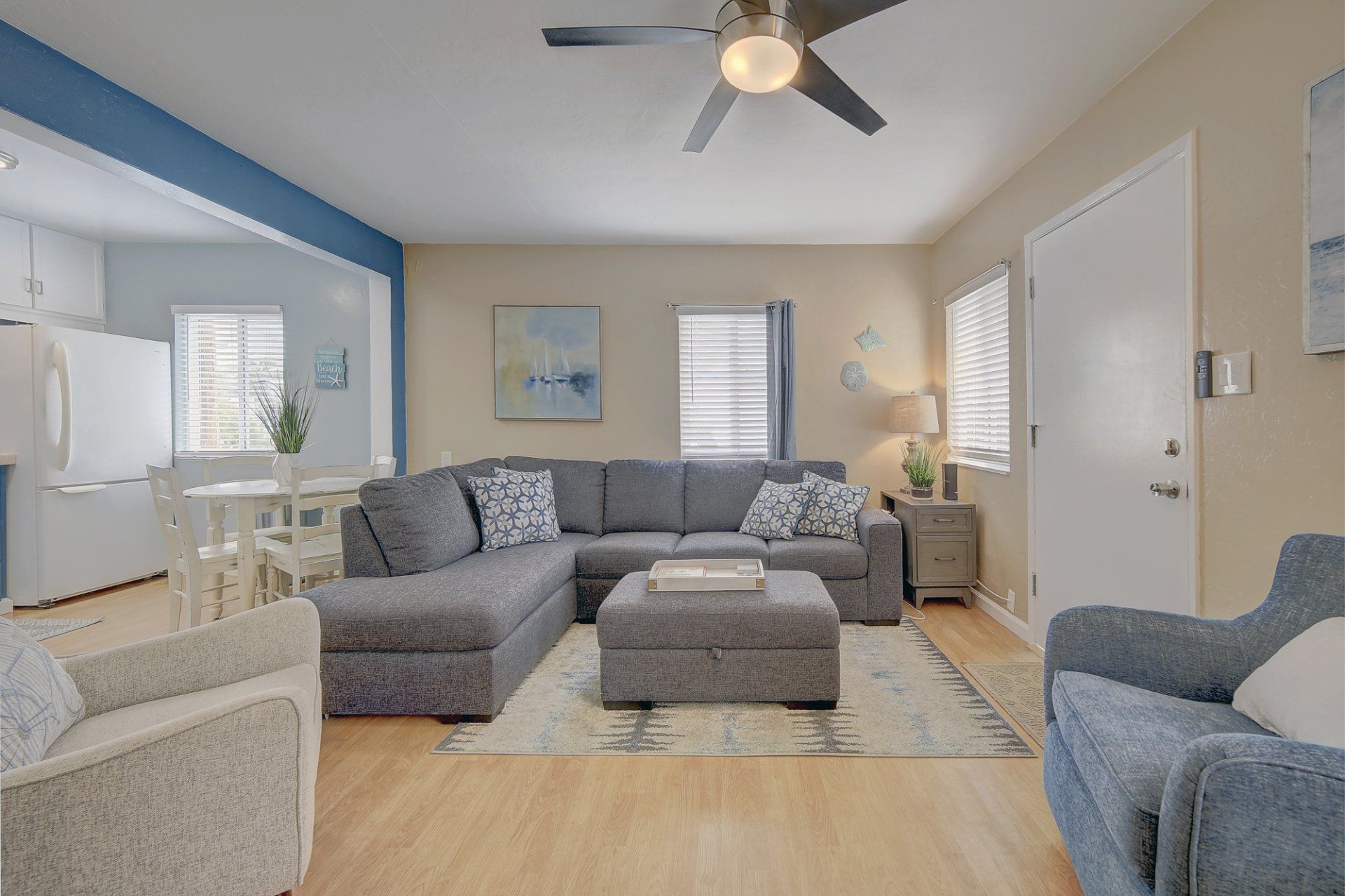 A living room with a couch , chairs , and a ceiling fan.