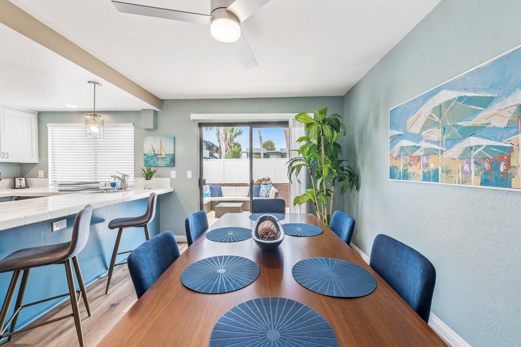 a dining room with a table and chairs and a ceiling fan .