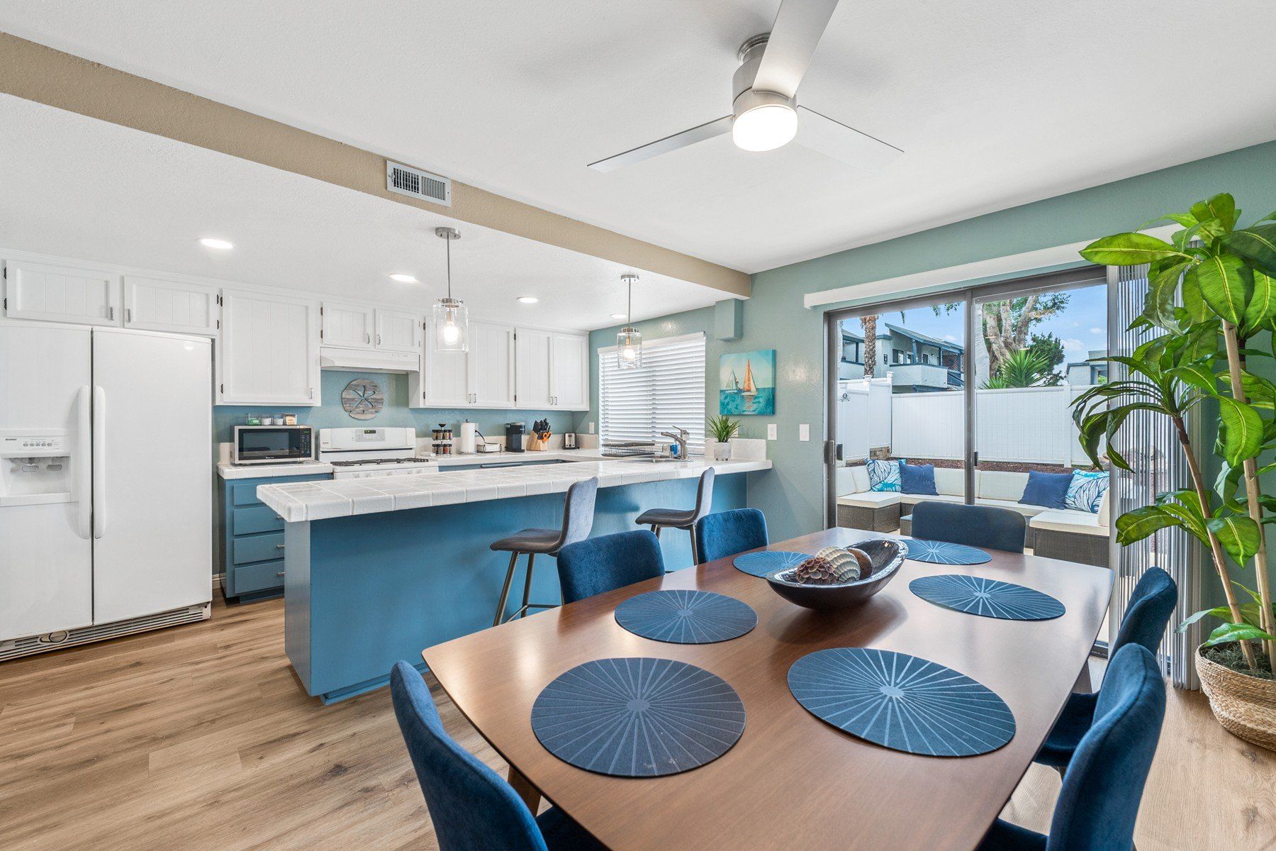 a dining room table and chairs in a kitchen with a ceiling fan .