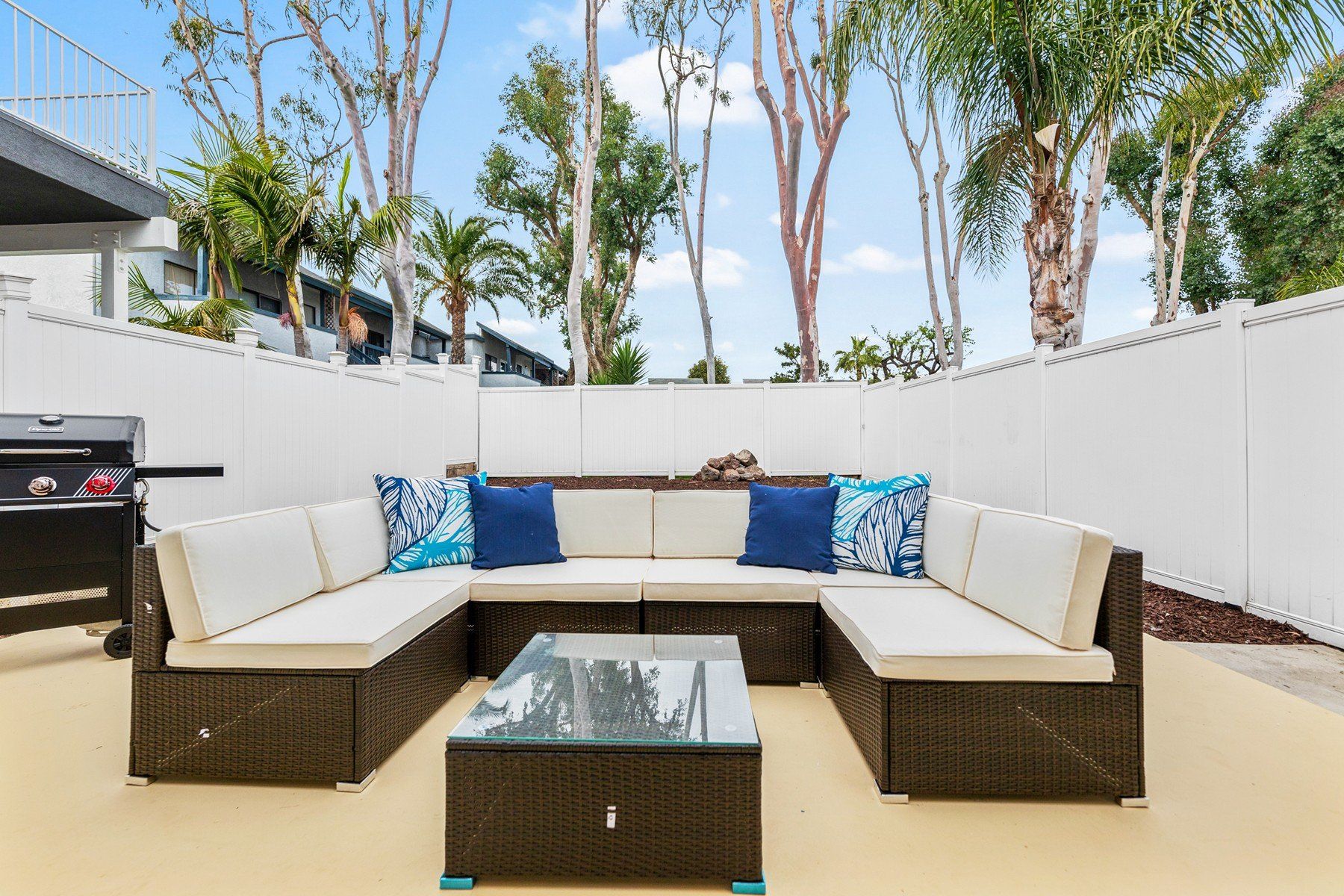 a patio with a sectional couch and a coffee table .