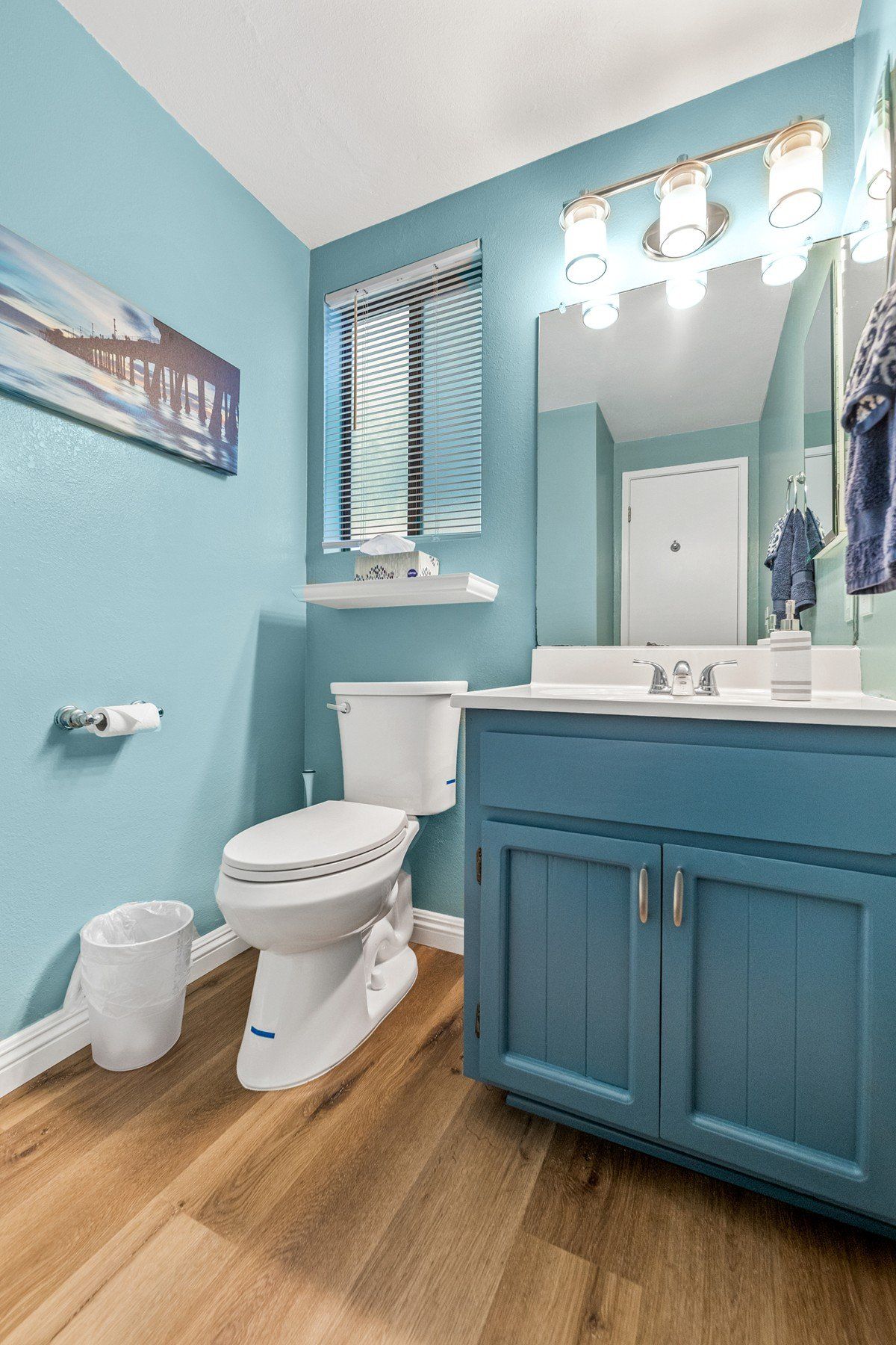 A bathroom with a toilet , sink and mirror.