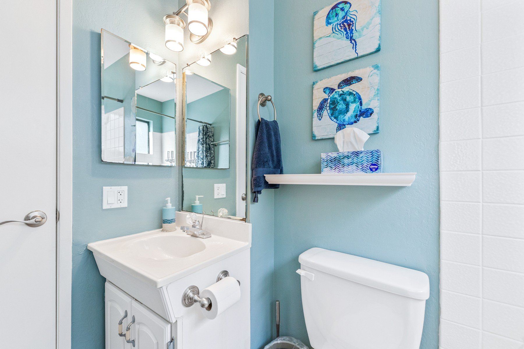 A bathroom with a sink , toilet and mirror.