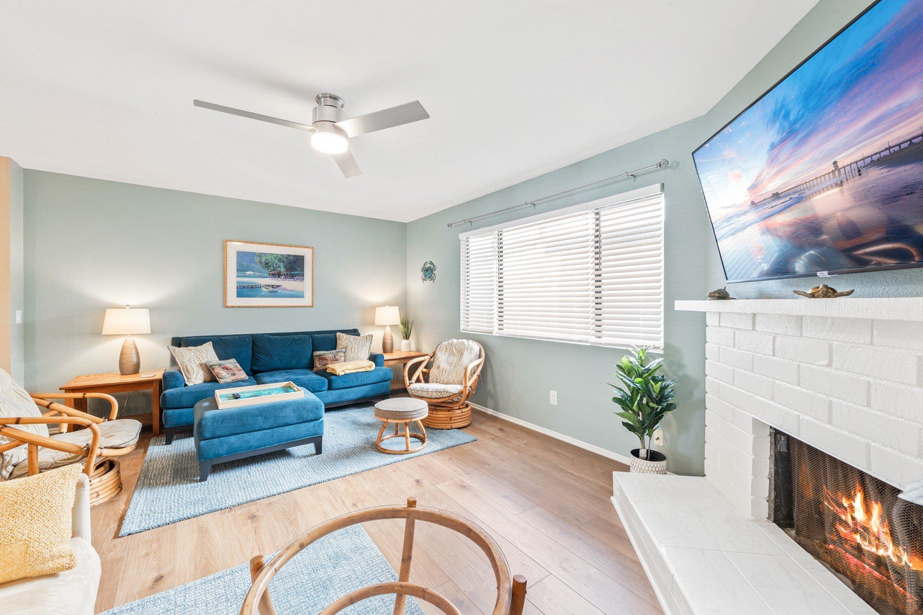 A living room with a couch , chairs , fireplace and television.