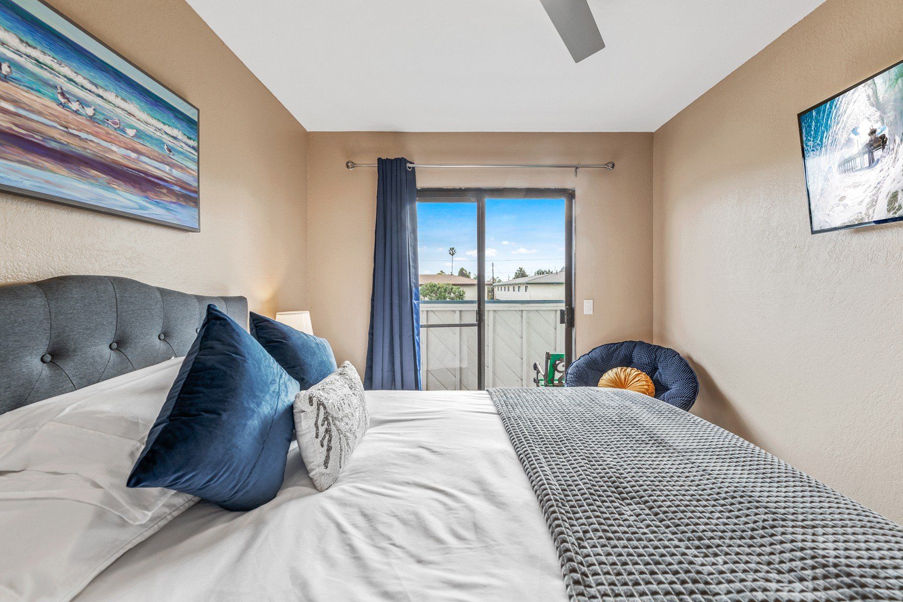 a bedroom with a large bed and a sliding glass door leading to a balcony .