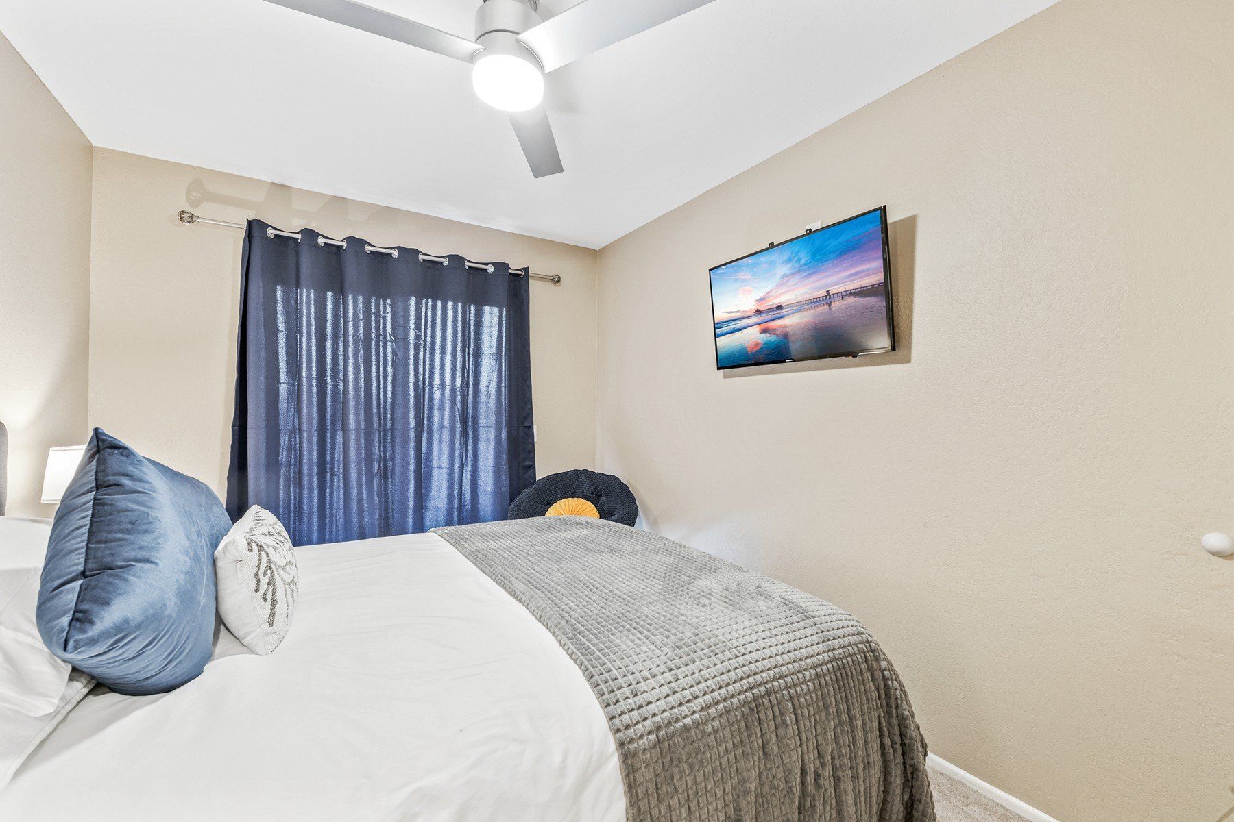 a bedroom with a bed , television and ceiling fan .