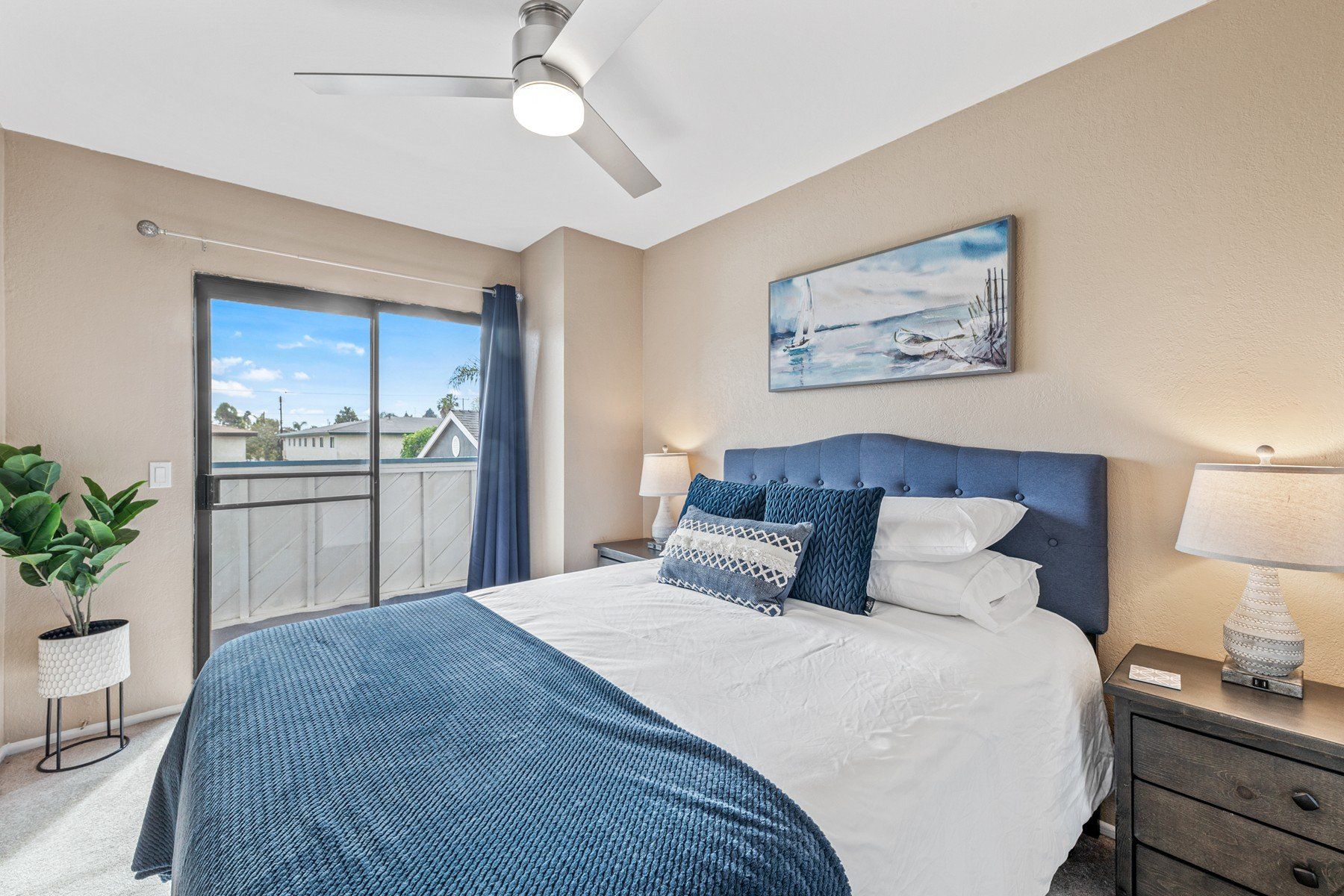 A bedroom with a large bed and a ceiling fan.