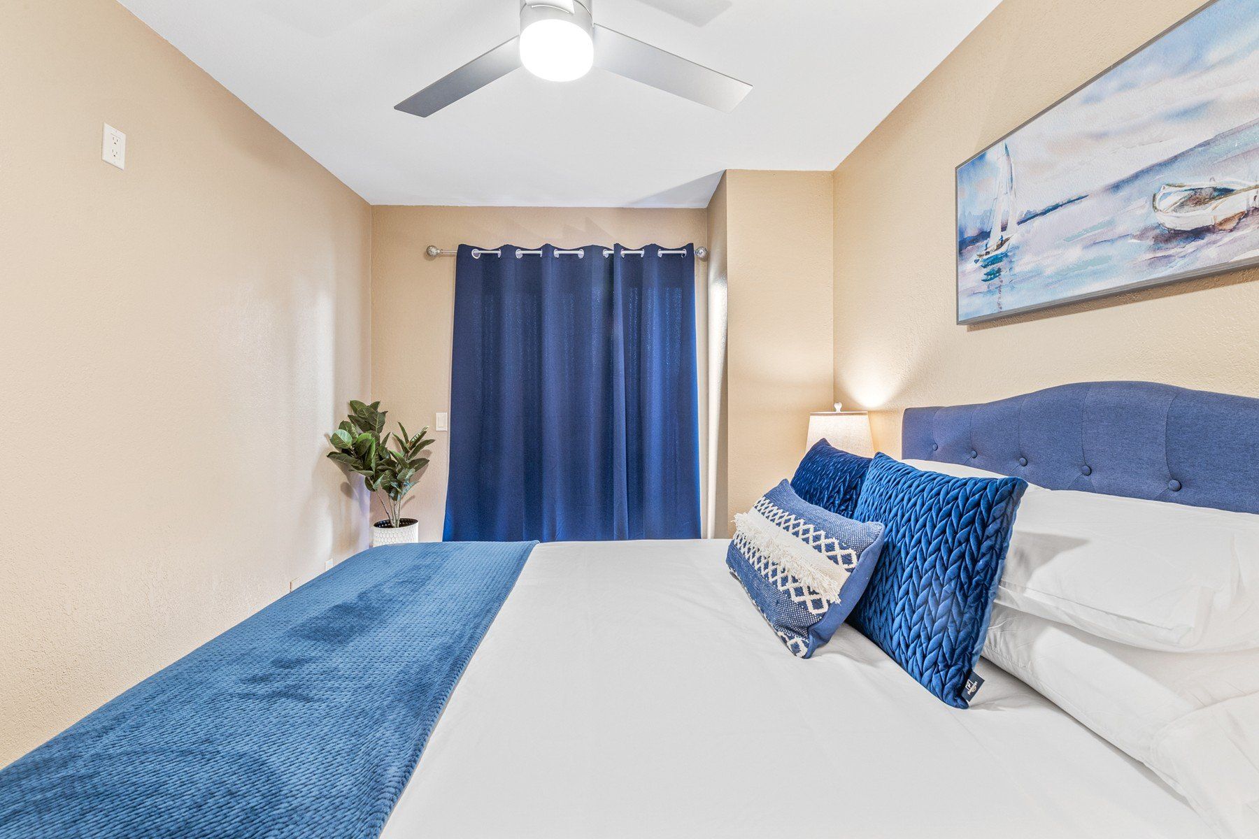 A bedroom with a large bed and a ceiling fan